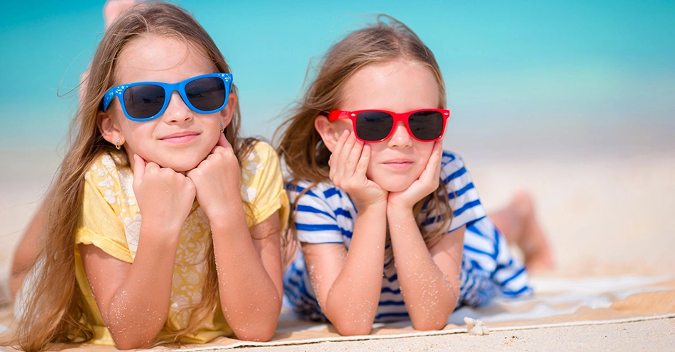 Девочки на пляже одеты в детские солнцезащитные очки Polaroid